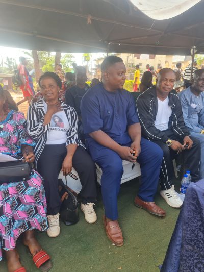 A row of seated guests smiling as they watch the sports day.