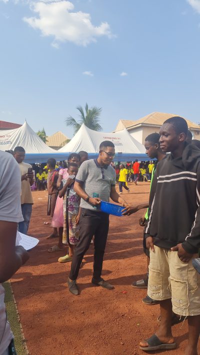 Two men standing together at the edge of the crowd at the sports day.