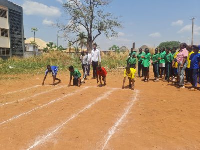 Runners in green and blue kit racing along the track.